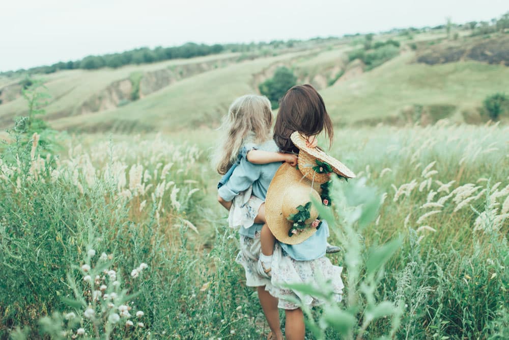 Young mother and daughter playing on grass